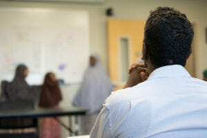Councilmember Warsame listens to presentation from children of Avivo's ESL students