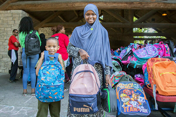 Two backpack recipients at Wells Fargo's Backpack Giveaway event for Avivo program participants and their families.