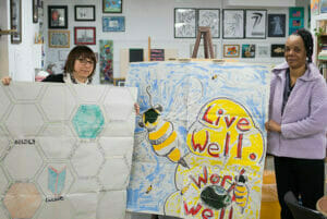 Two artists display a mural in the works as part of Avivo ArtWorks.