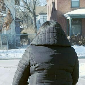 A mom walks with her baby outside in winter.
