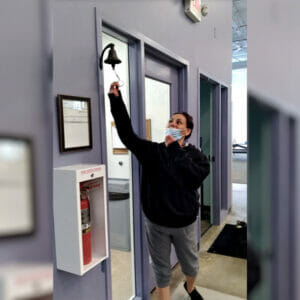 An Avivo Village resident finds housing and rings the bell to start a celebration at the village.