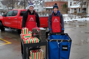 Adopt-A-Family volunteers from Holy Angels Academy unload vehicles as they drop off some of the record number of donations received in this year's program.