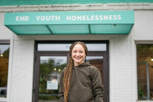 Kenzie from Wildflyer Coffee, a nonprofit coffee shop working to end youth homelessness, poses for the camera.