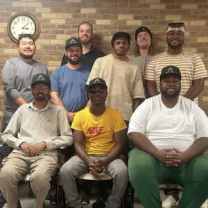 At a gathering of Avivo's Xcel Energy Power Up Construction Trades Pre-Apprentice Training graduates, a group of graduates and staff pose for a photo.