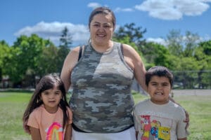 Megan, a successful participant in Avivo's programs, poses for a photo with her children.