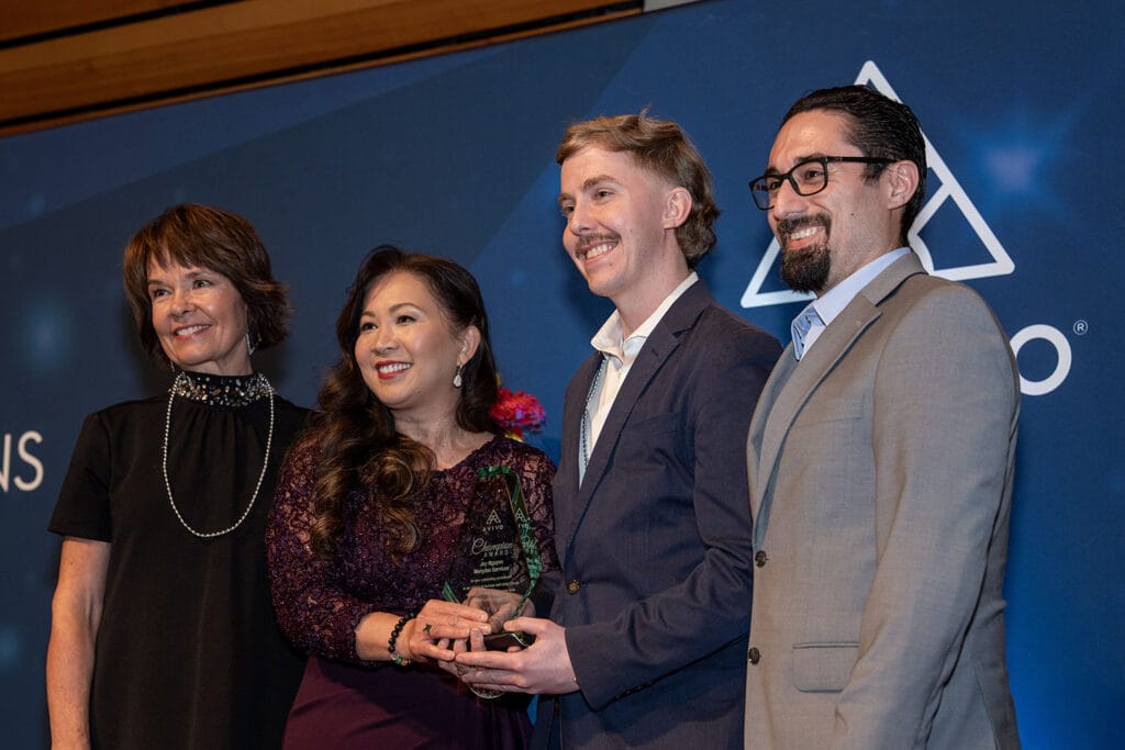 Joy Nguyen accepts an Avivo Champion award, while standing with Avivo and Marsden staff.